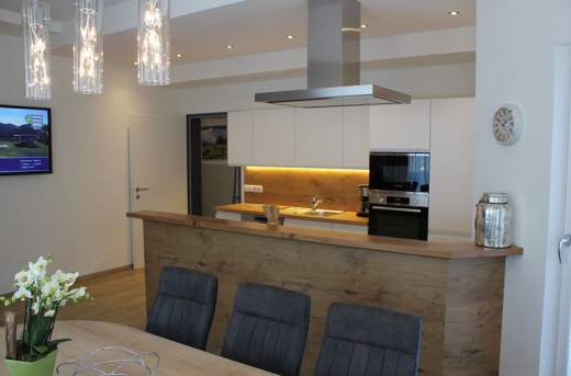 Wohnküche mit großer Essecke und Flat-TV im Appartement E